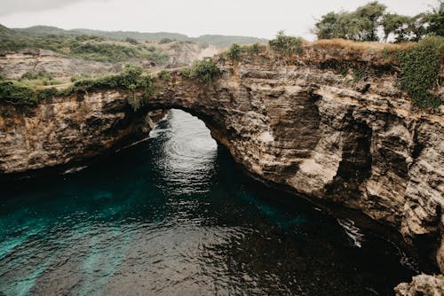 Montaña Rocosa Marrón Junto Al Cuerpo De Agua