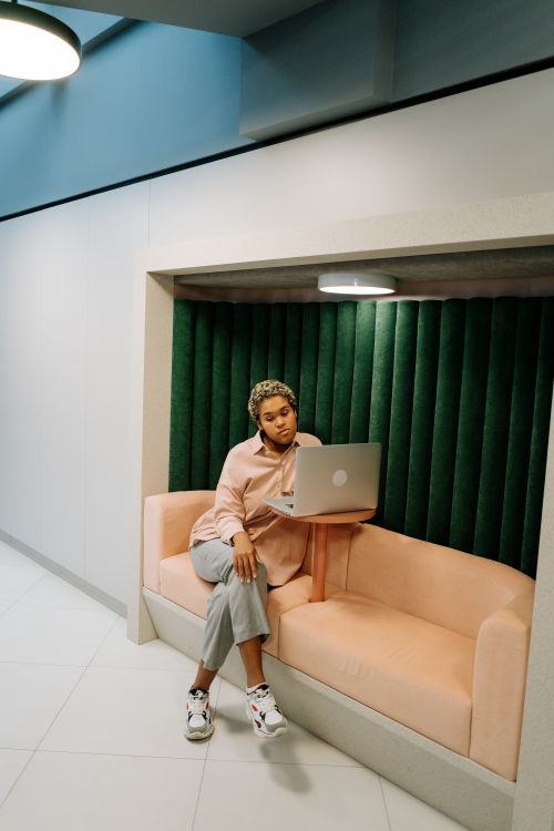 Free African American woman working on a laptop in a stylish alcove. Modern interior design. Stock Photo
