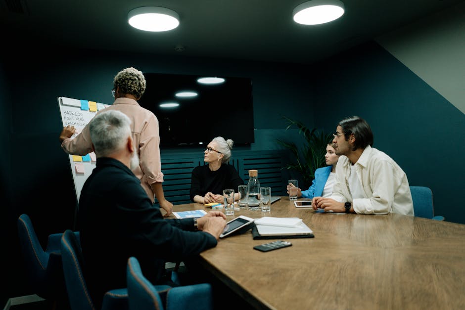 A diverse team of senior professionals engaged in a strategic discussion, showcasing their hands-on expertise in project management and Lean Six Sigma within a modern office environment.. Snapped by cottonbro studio