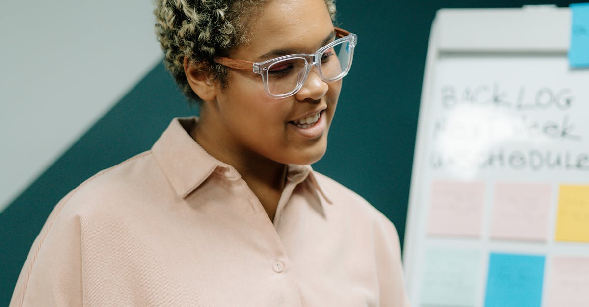 Confident woman presenting in a business meeting using a whiteboard and notes.