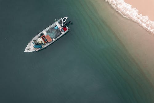 Motorboat moored on seawater near sandy beach