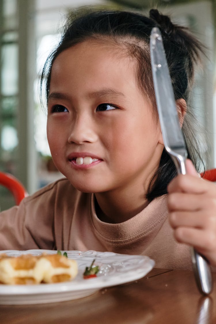 Close Up Photo Of A Girl Holding A Table Knife