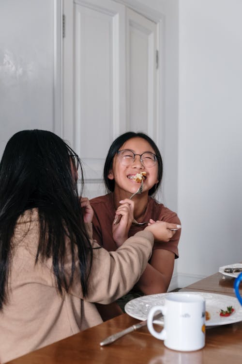 Free Woman in Brown Long Sleeve Shirt Eating Stock Photo