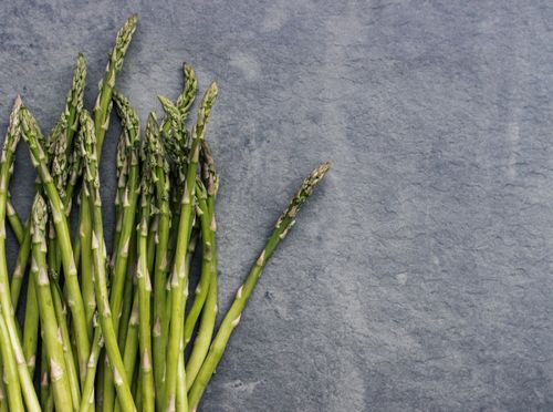 Free Close-up of fresh asparagus stalks on a textured slate background, perfect for health and food themes. Stock Photo