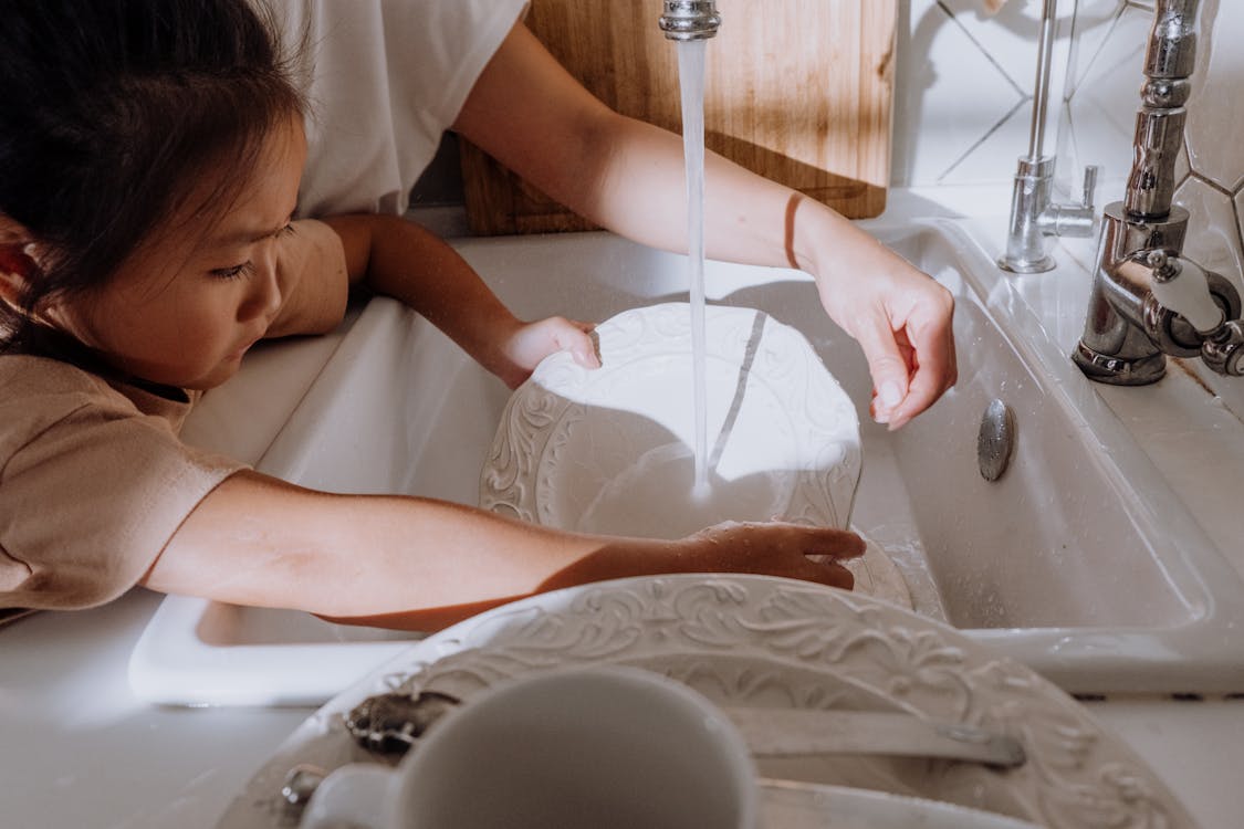 Free Industrious Young Girl cleaning the Dishes Stock Photo