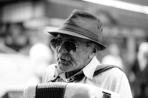 Grayscale Photo of an Elderly Man Wearing Hat