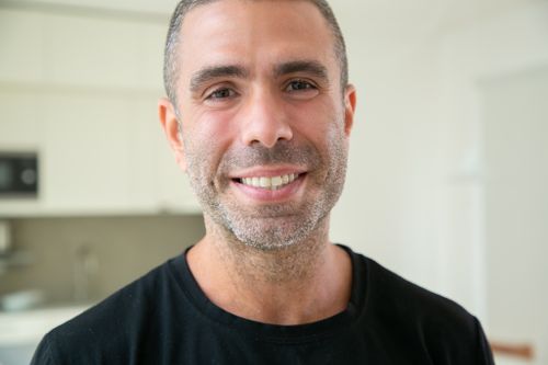 Free Close-up portrait of a happy man smiling indoors, exuding positivity and warmth. Stock Photo
