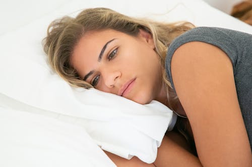 Close Up Photo of a Woman Lying on Bed