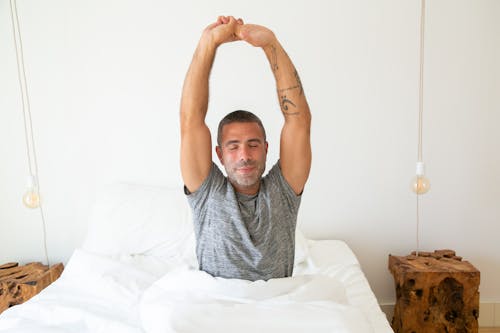 Free Man in Grey T-shirt stretching His Arms Stock Photo