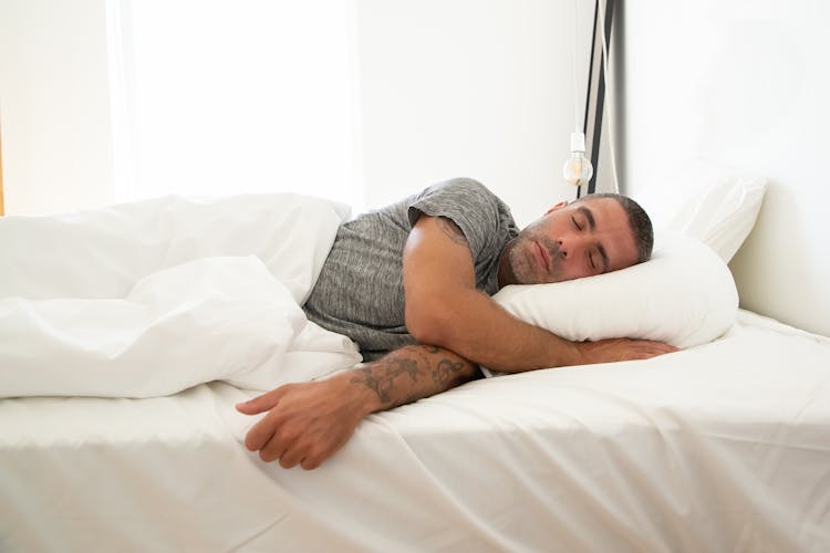 Man In Gray Shirt Lying On The Bed