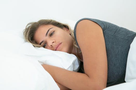 Donna In Canottiera Grigia Sdraiata Sul Letto