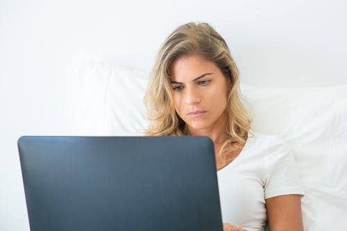 Wanita Berkemeja Putih Memegang Komputer Laptop Hitam