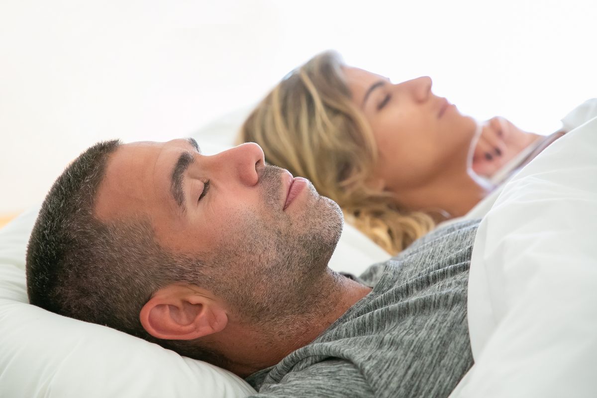 Couple sleeping peacefully close together after fixing mouth breathing at night bad breath