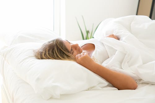 Woman in White Shirt Napping on Bed