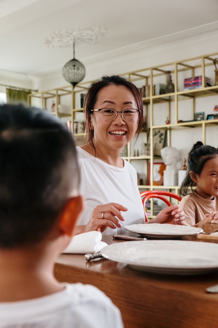 Mother Sitting With Her Children At A Table