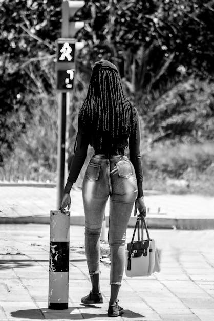 Black woman in stylish jeans walking on street · Free Stock Photo