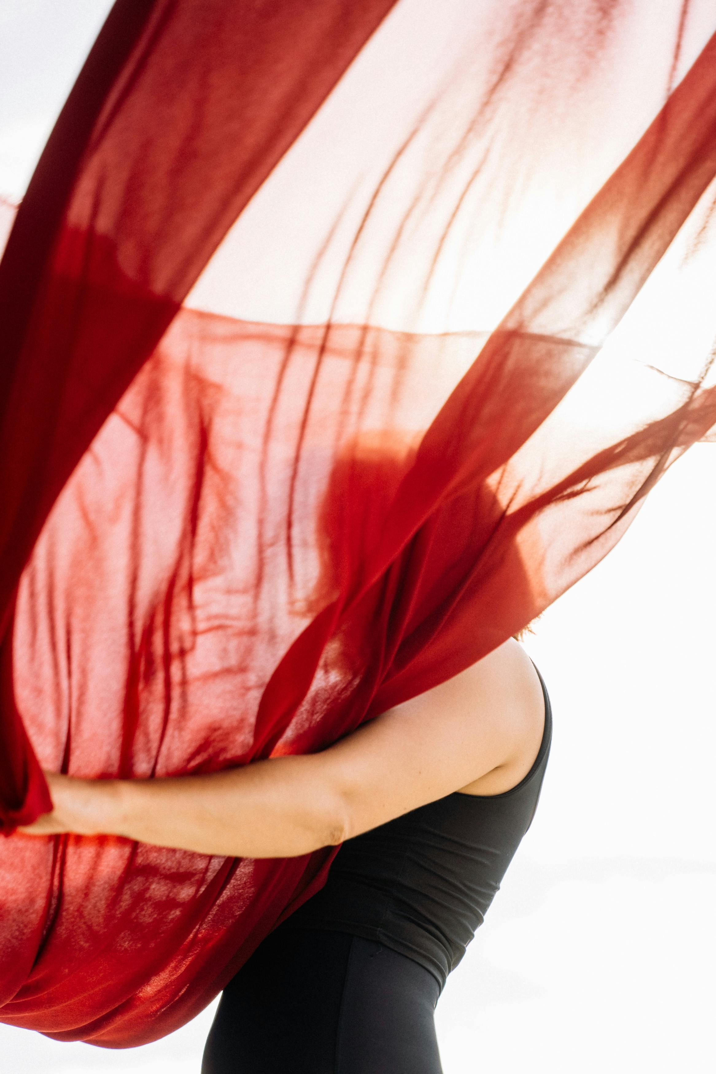 Free Artistic photo of a dancer with a flowing red fabric in movement, capturing grace and motion. Stock Photo