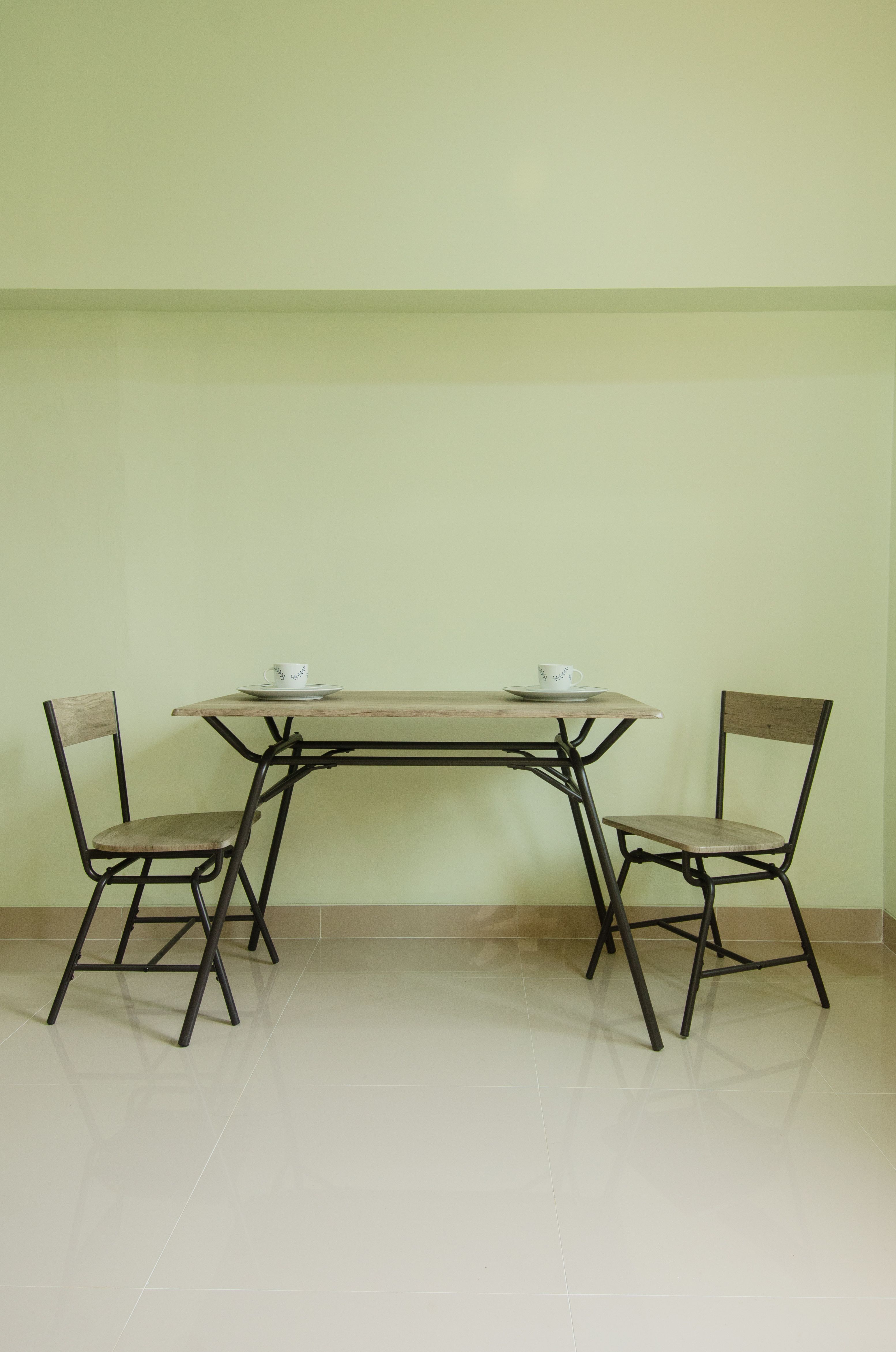 Colț de sufragerie minimalist, cu o masă din lemn și două scaune simple din lemn