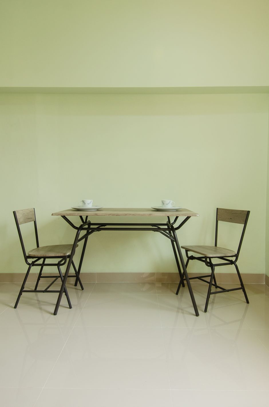 Simple minimalist dining area with two wooden chairs and table.