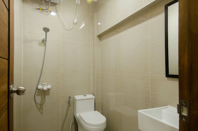 A Bathroom With Toilet And Shower