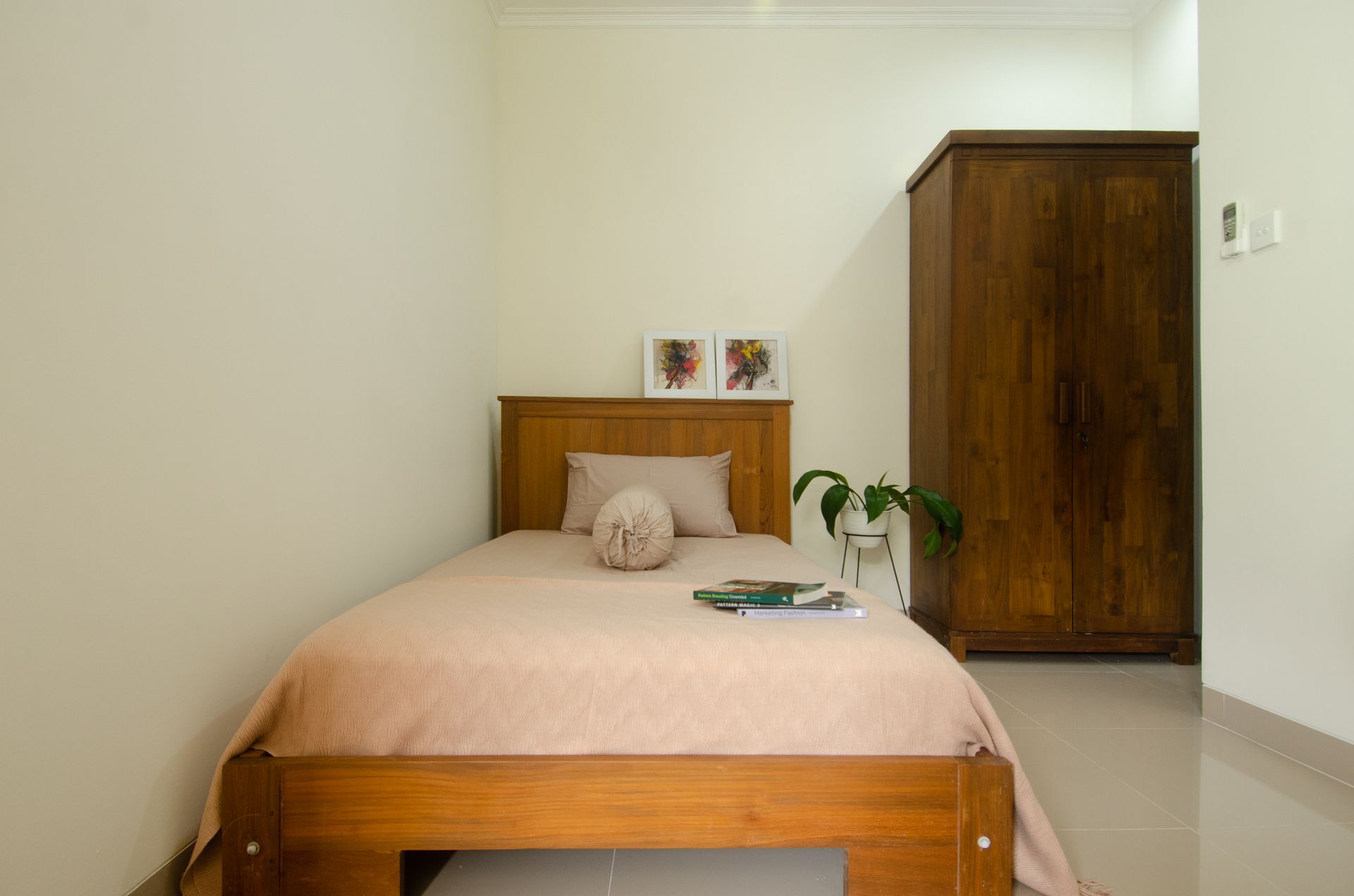 Cozy minimalist bedroom featuring wooden furniture and indoor plant.