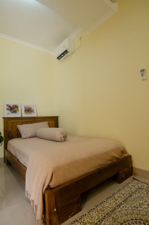 Бесплатное стоковое фото с вертикальный выстрел, деревянная кровать, изголовье кровати