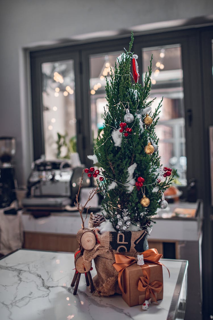 Small Christmas Tree With Decorations On Table