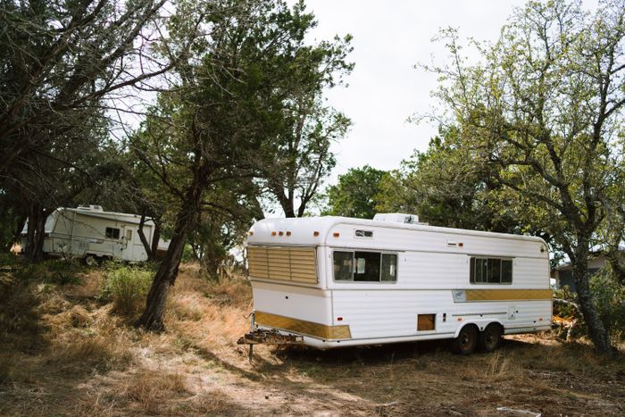 RV trailer parked near green trees