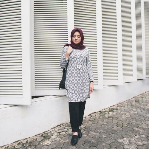 Free Fashionable woman in a patterned hijab posing against modern architecture outdoors. Stock Photo