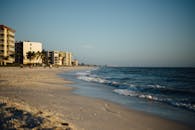 阳光明媚的海滩波光粼粼，以城市天际线为背景，非常适合放松