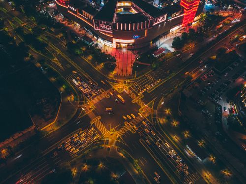 Free A nighttime aerial view of a brightly lit intersection in Xiamen, China, showcasing urban life with heavy traffic. Stock Photo