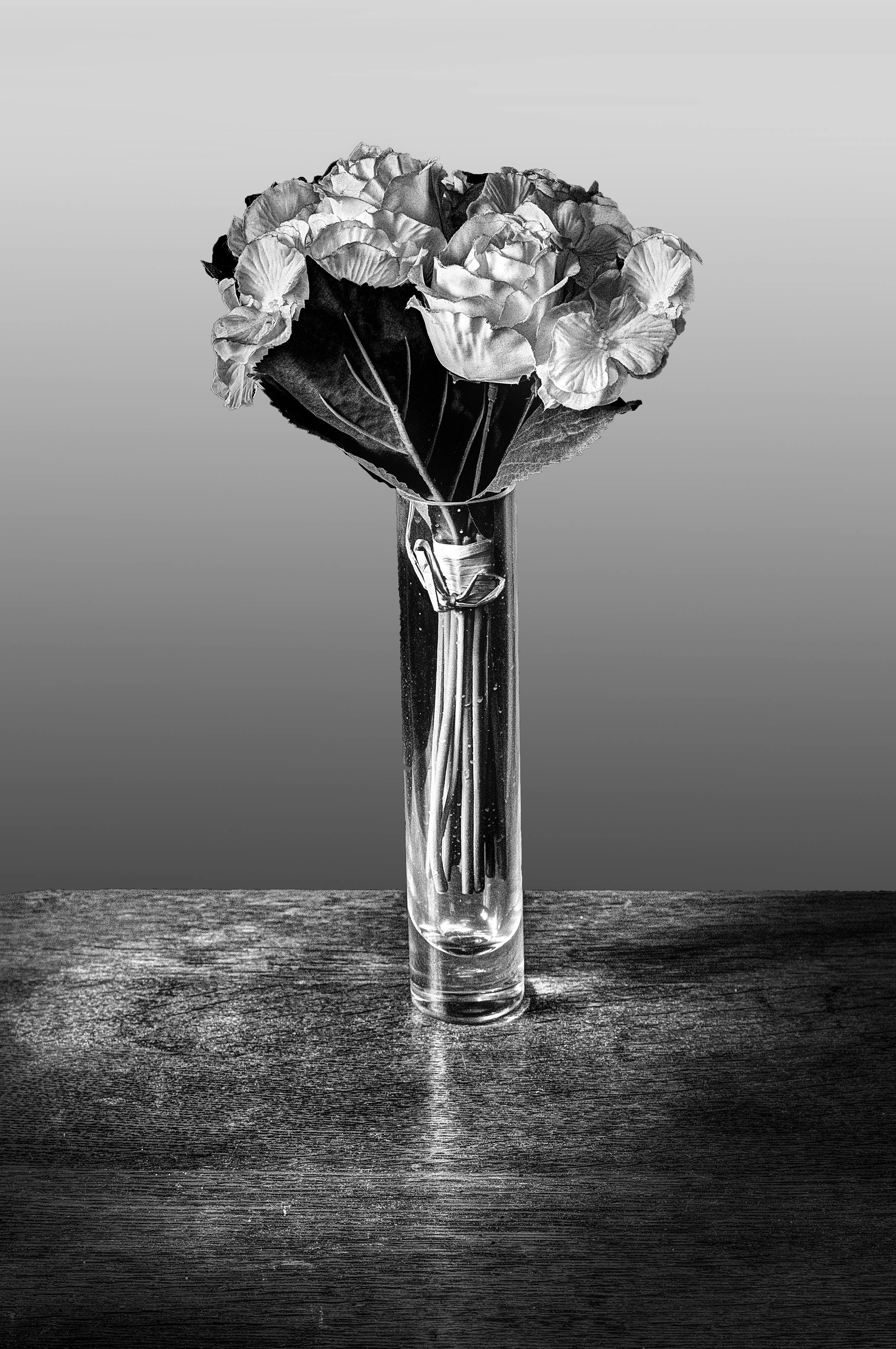 Monochrome image of flowers in a glass vase, showcasing elegant floral arrangement.