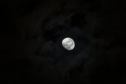 Majestic glowing moon surrounded with clouds