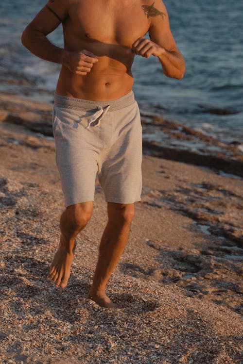 Topless Man Running at the Beach