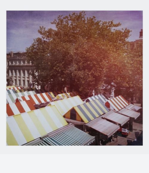 Free Vibrant market stalls with striped awnings in Norwich, creating a lively urban scene. Stock Photo
