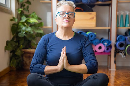 Free Woman in Blue Long Sleeve Shirt Meditating Stock Photo