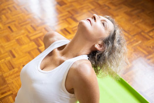 An elderly woman stretching on a yoga mat, promoting fitness and a healthy lifestyle.