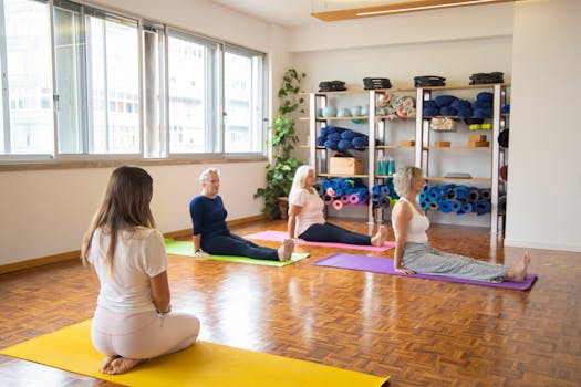 A diverse group of senior women practicing yoga indoors with mats.