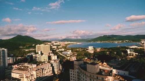 Free A breathtaking aerial view of a coastal city with mountains in the background under a clear blue sky. Stock Photo