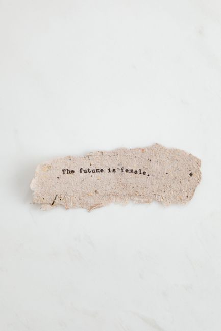 Torn paper with text 'The future is female.' on a white background.