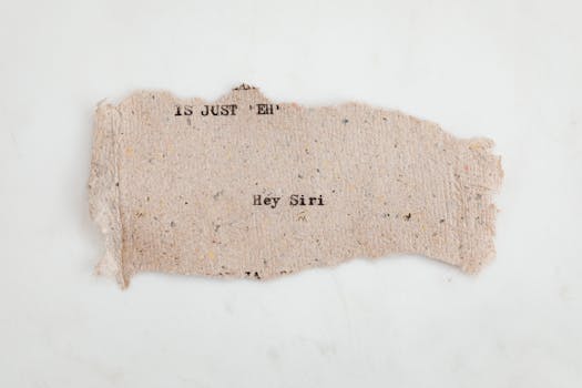 A torn piece of textured paper with text 'Hey Siri' and a white background.