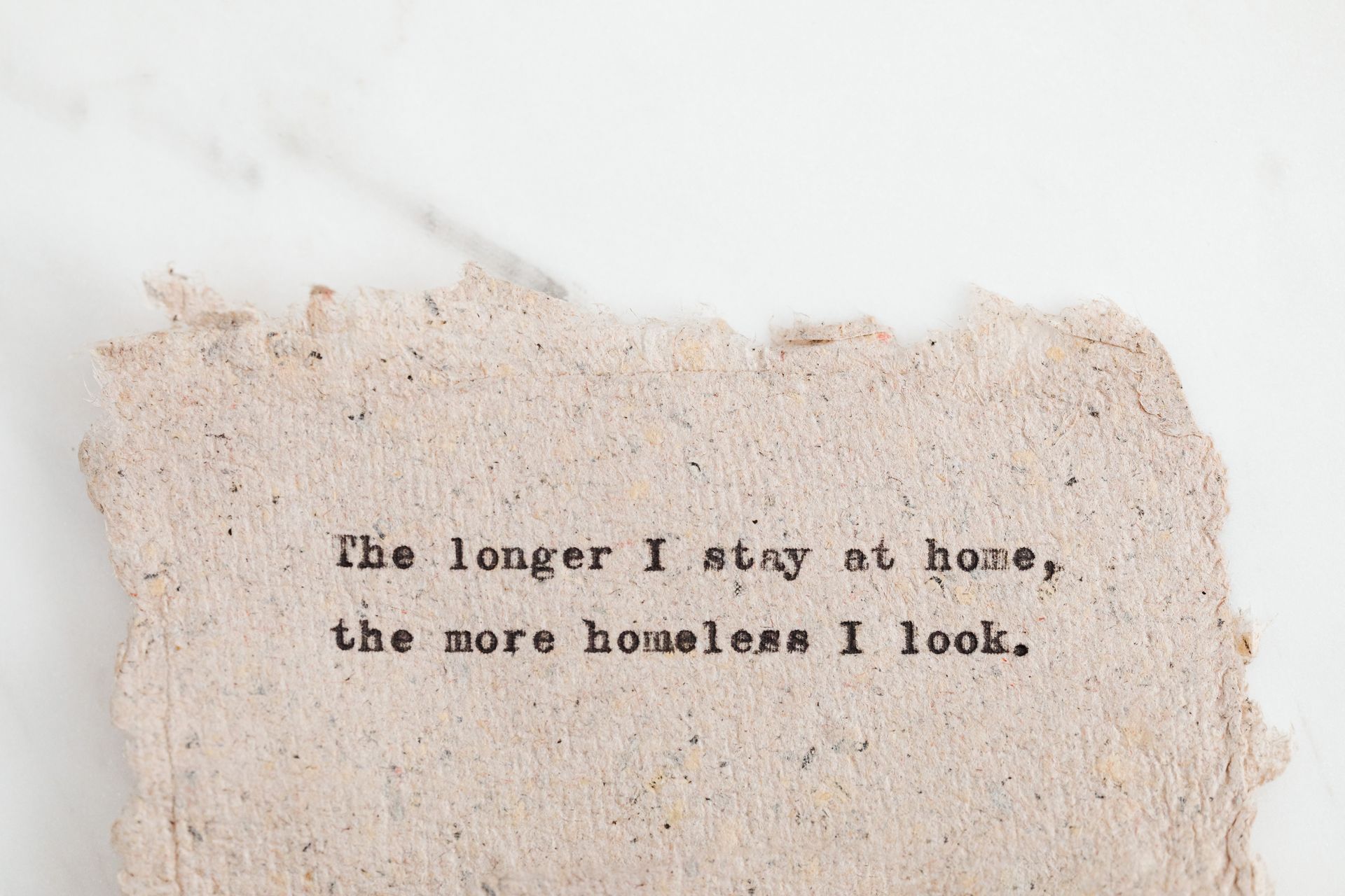 Text message on recycled paper with a humorous quote about staying home.