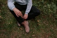 Person in Gray Long Sleeve Shirt and Black Pants Sitting on Green Grass