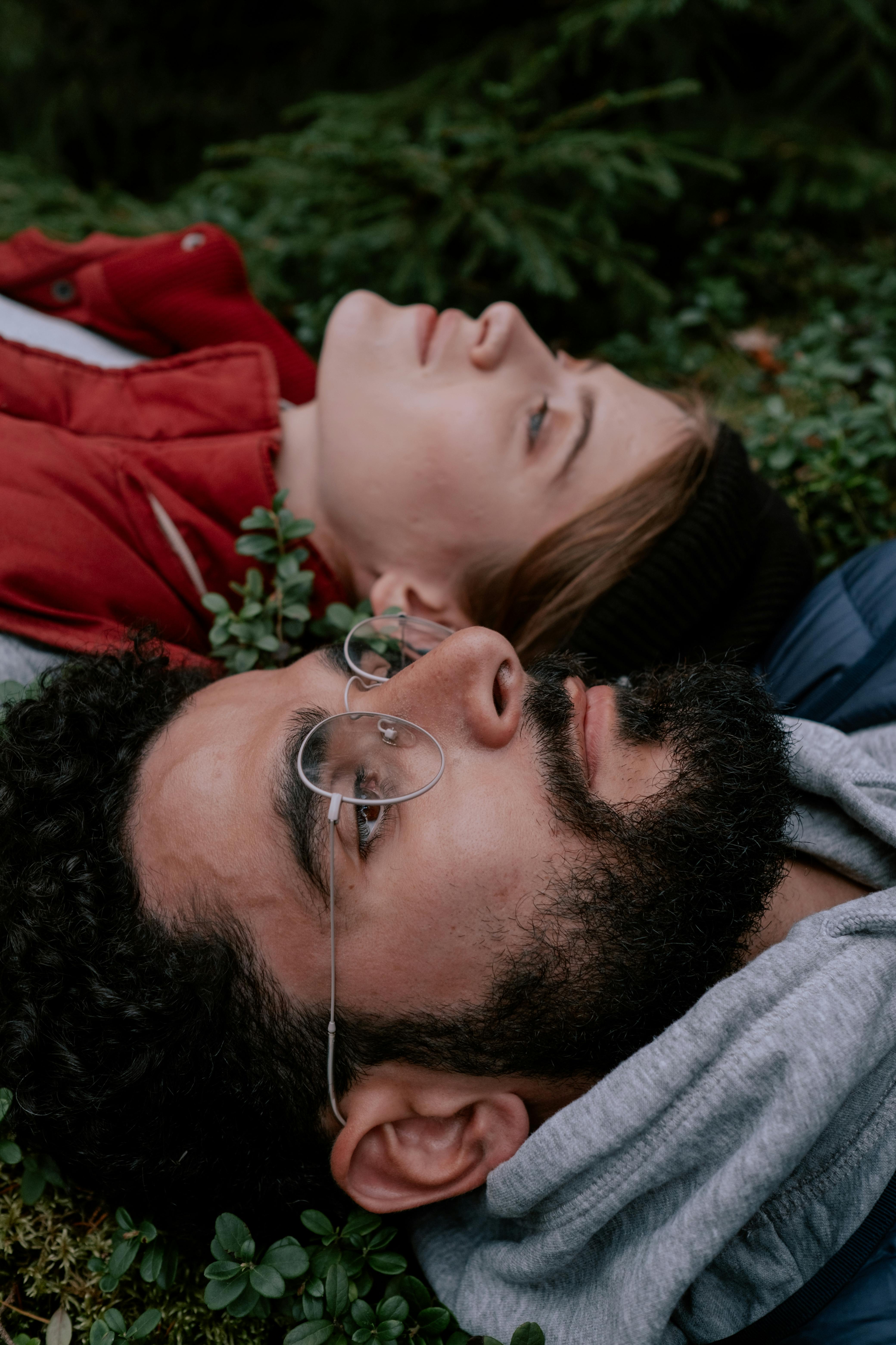 一对轻松的夫妇躺在绿植上，拥抱自然与宁静