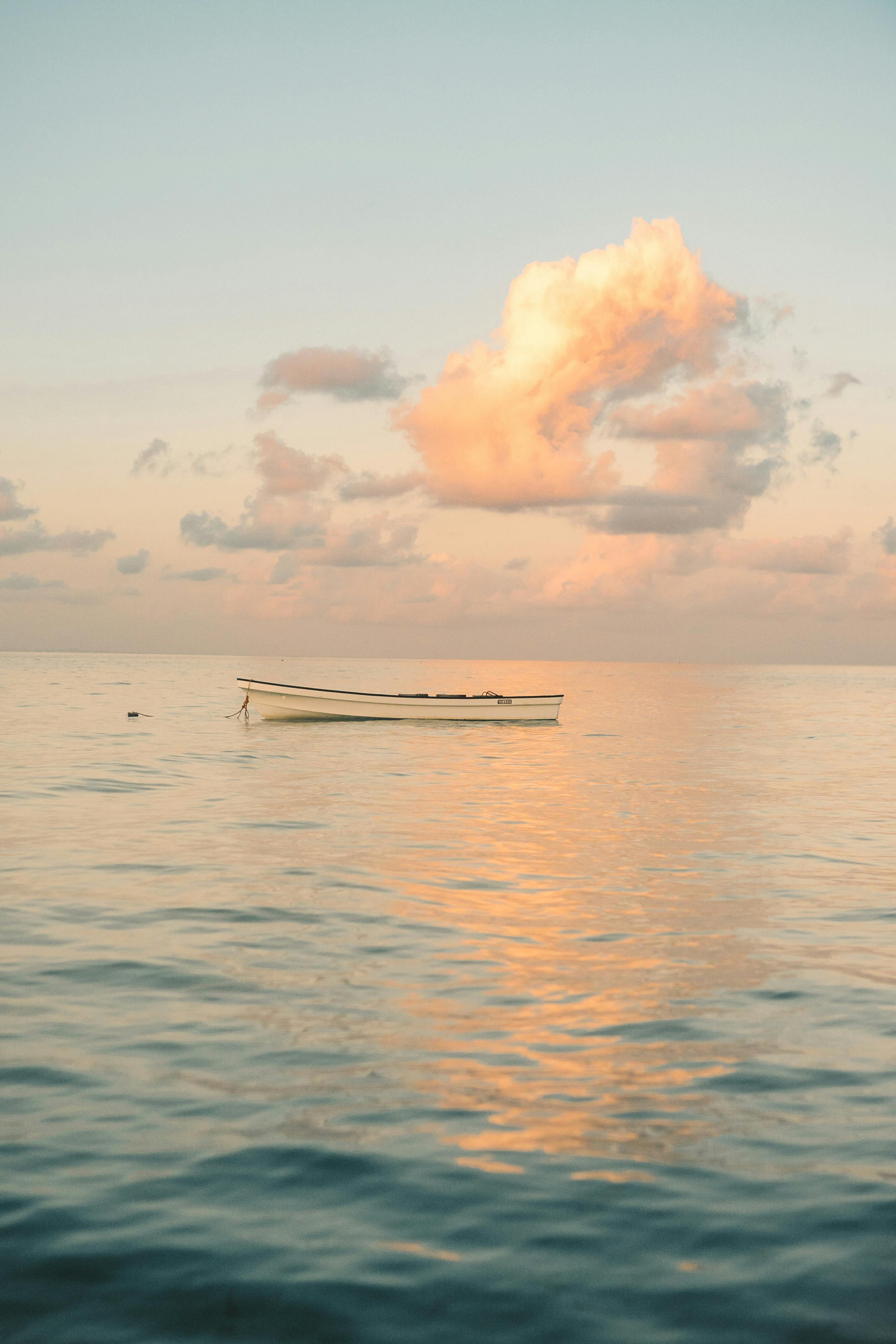 平静的桑给巴尔水域上宁静的日落景色，有一艘孤独的船和壮观的云层