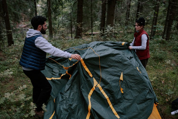 Man And Woman Setting Up A Tent