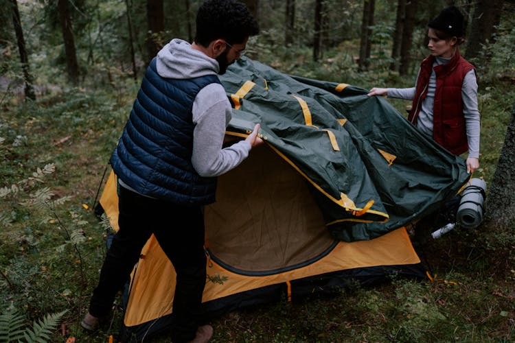 Man And Woman Setting Up A Tent