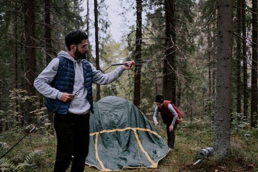 A couple assembling a tent in a wooded forest, enjoying an outdoor camping adventure.