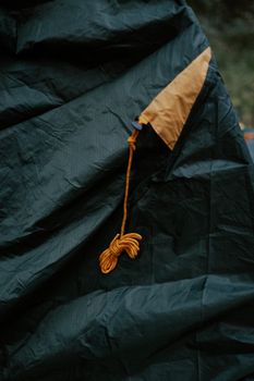 绿色背景下，帐篷织物上打结的绳子细节清晰可见