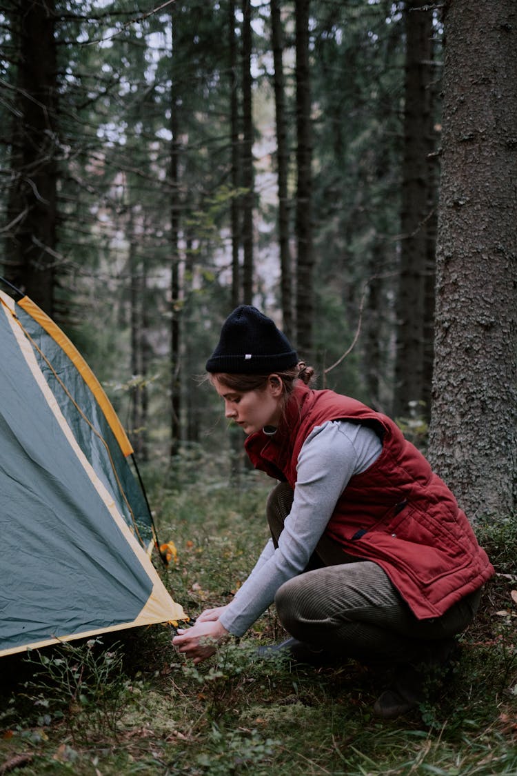 A Woman Setting Up A Camping Tent